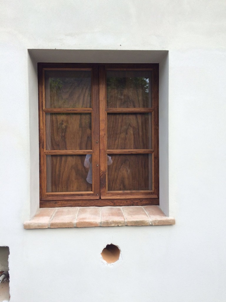Finestre in legno anticate e rifinite a mano, con venature evidenti e telaio restaurato
